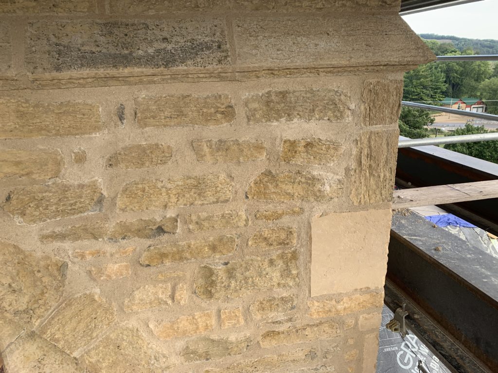 Stone replacement and repointing work on the tower during masonry restoration